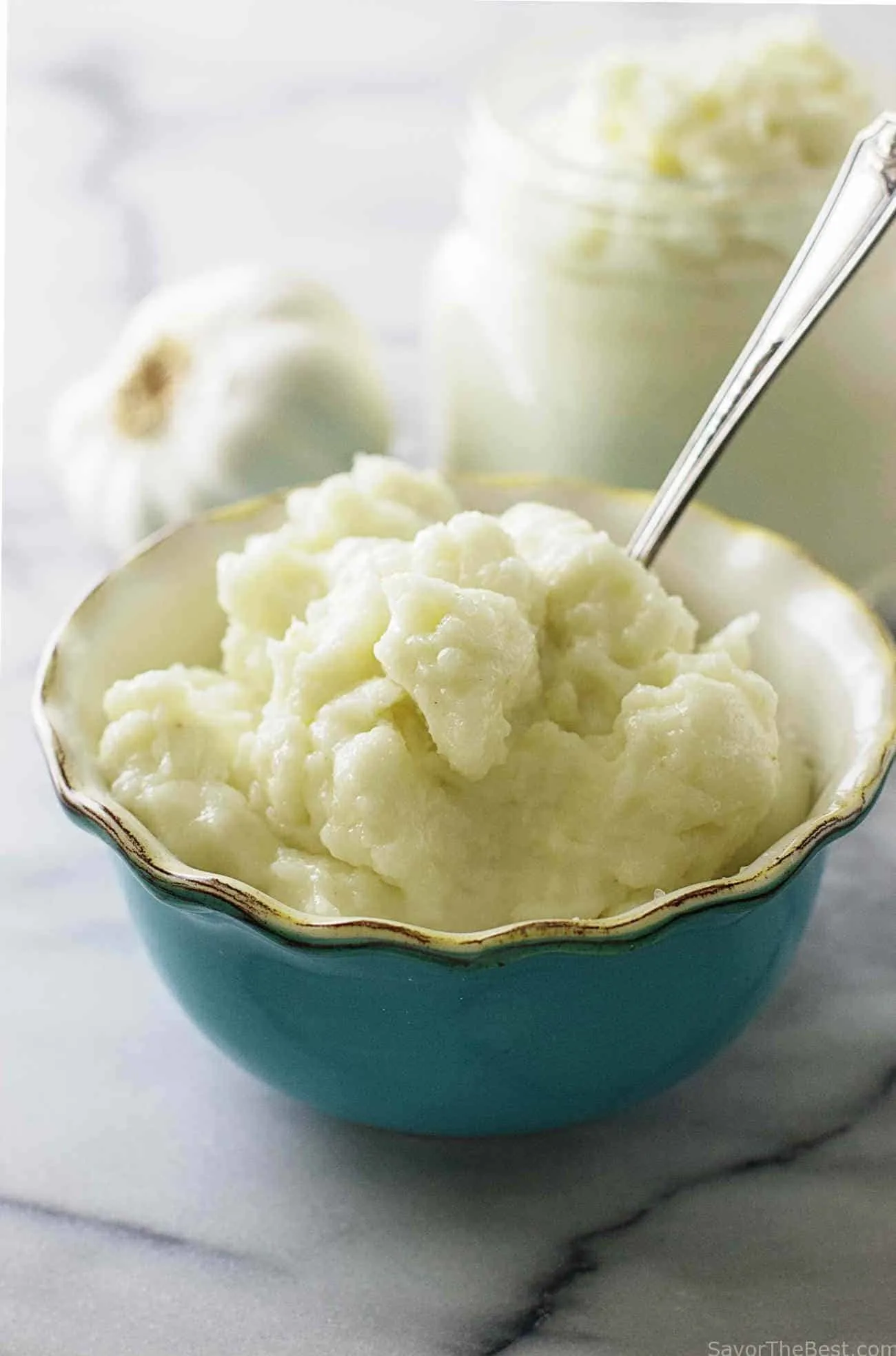 thick creamy garlic sauce in a blue ceramic bowl.