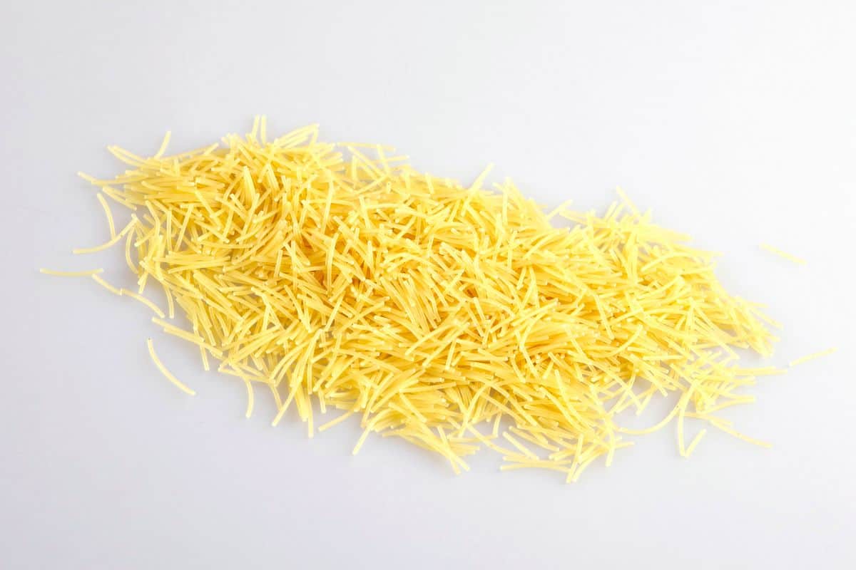 uncooked broken spaghetti on white surface.