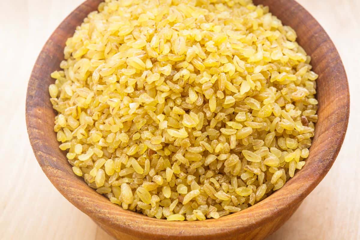 uncooked bulgur in a wooden bowl.