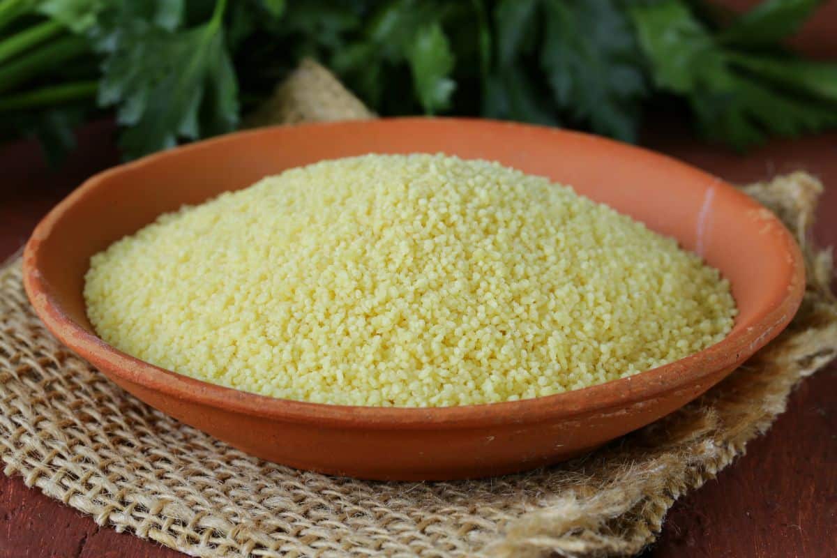 uncooked couscous in a teracotta bowl.