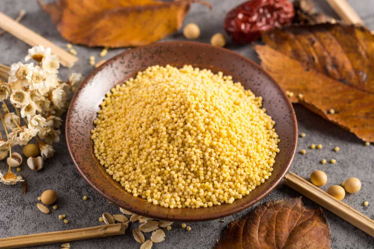 uncooked millet in a brown bowl.