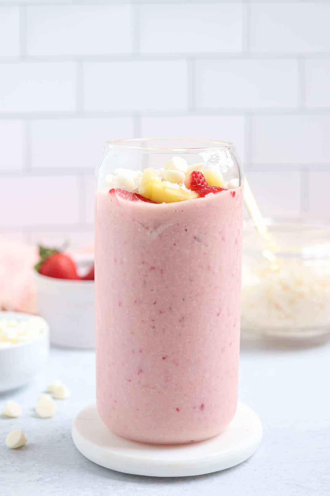 bahama mama smoothie made with frozen strawberries, pineapple, white chocolate and coconut in a tall glass.