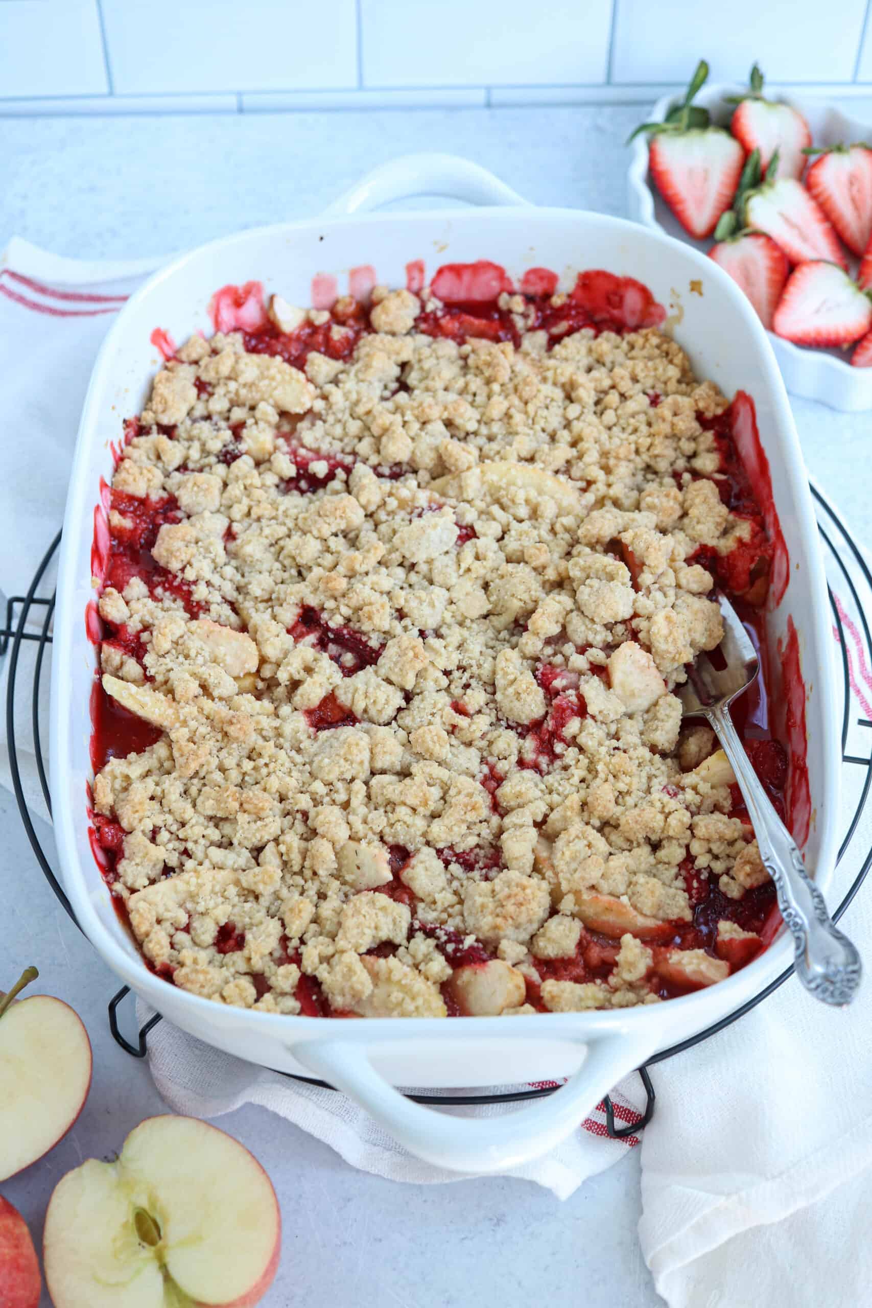 strawberry apple crisp in a white casserole dish.