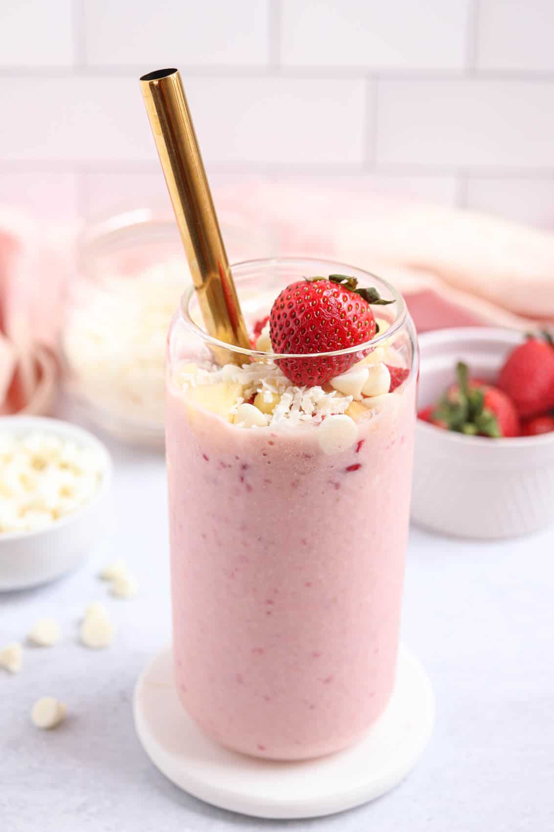 bahama mama smoothie made with frozen strawberries, pineapple, white chocolate and coconut in a tall glass.