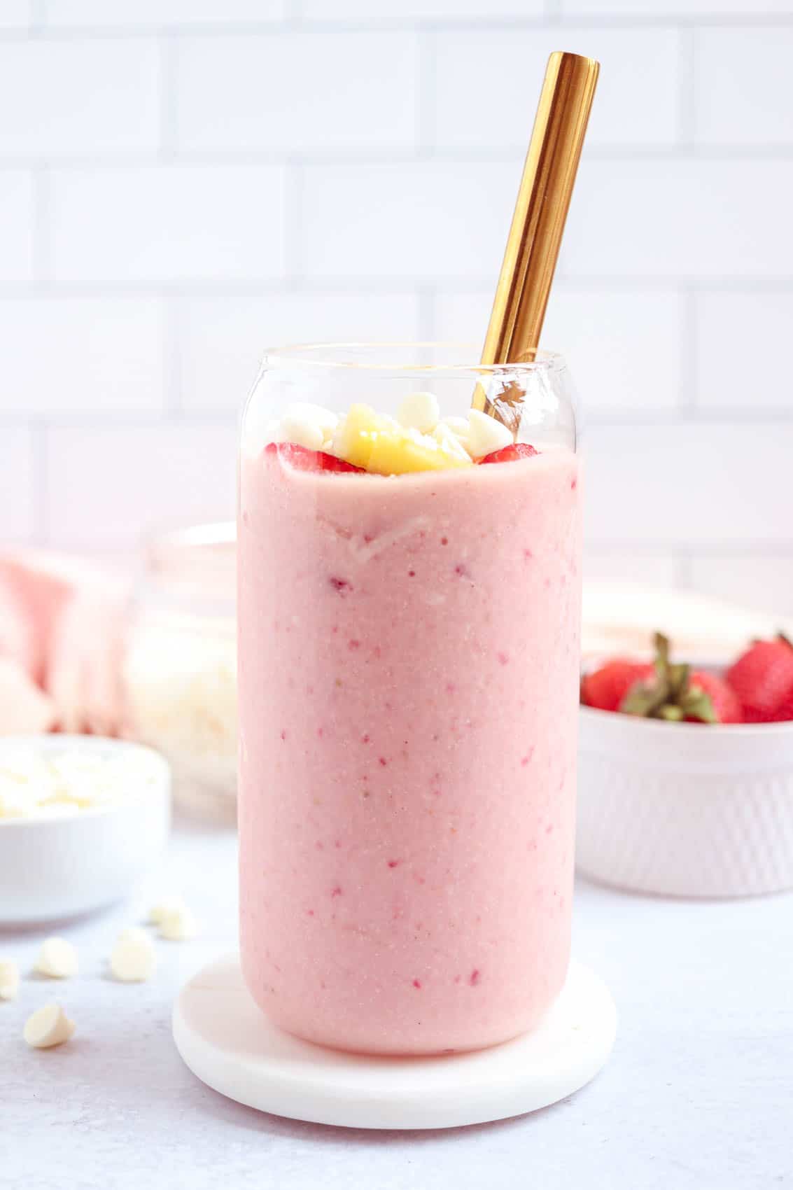 bahama mama smoothie made with frozen strawberries, pineapple, white chocolate and coconut in a tall glass.