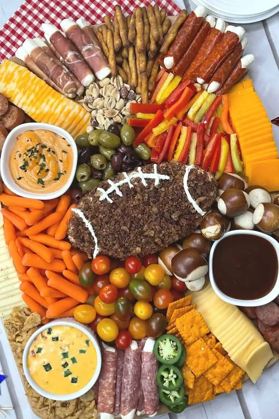 football charcuterie board with veggies and dips.