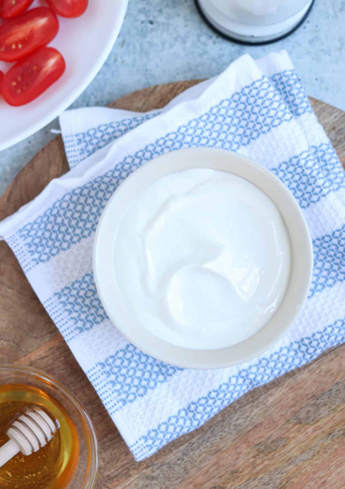 blended cottage cheese in a small white bowl on a white and blue kitchen towel. 