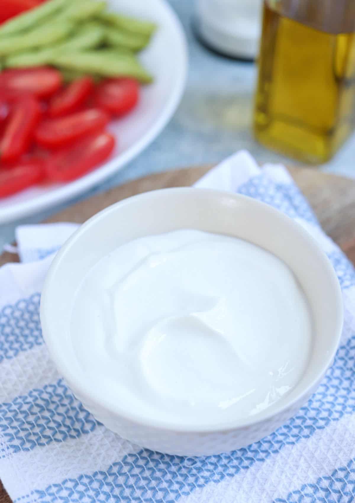 blended cottage cheese in a small white bowl on a white and blue kitchen towel. 