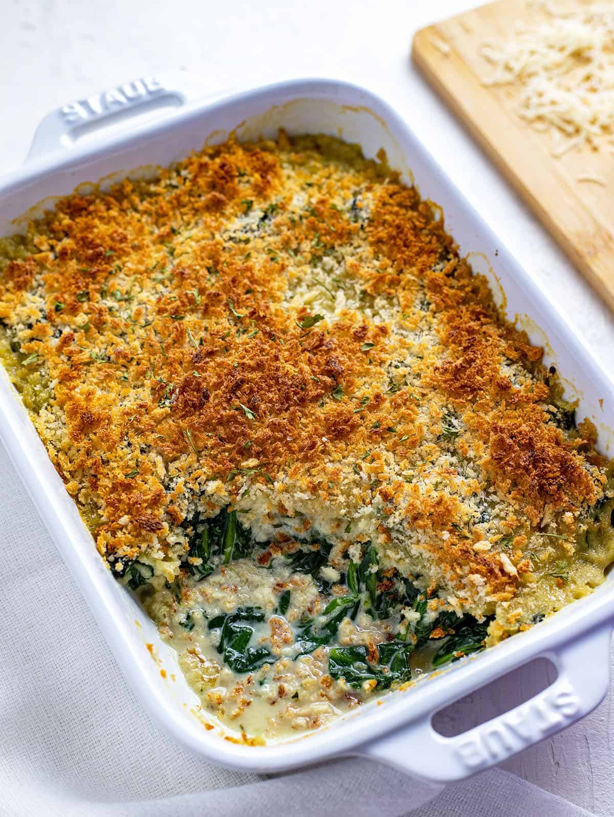 spinach au gratin in a white casserole dish.