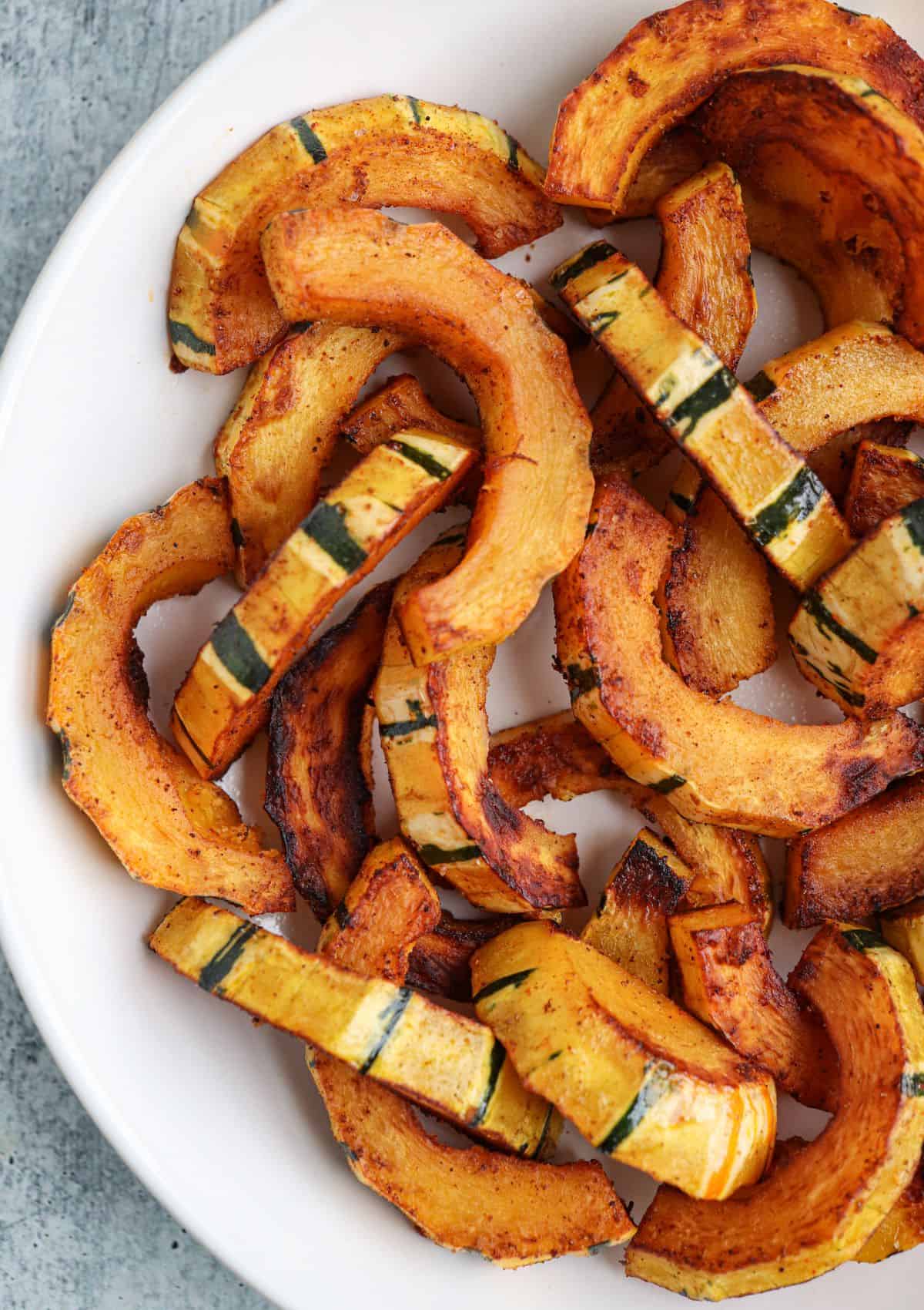 sautéed sliced delicata squash in a white bowl.