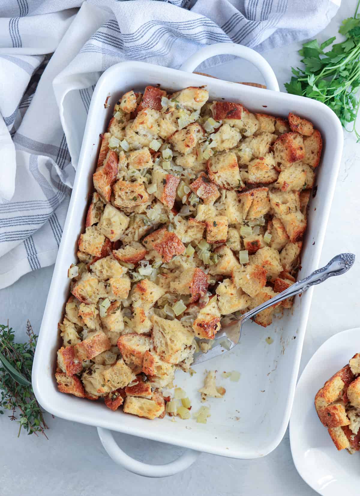 sourdough bread stuffing baked in a white rectangular baking dish.