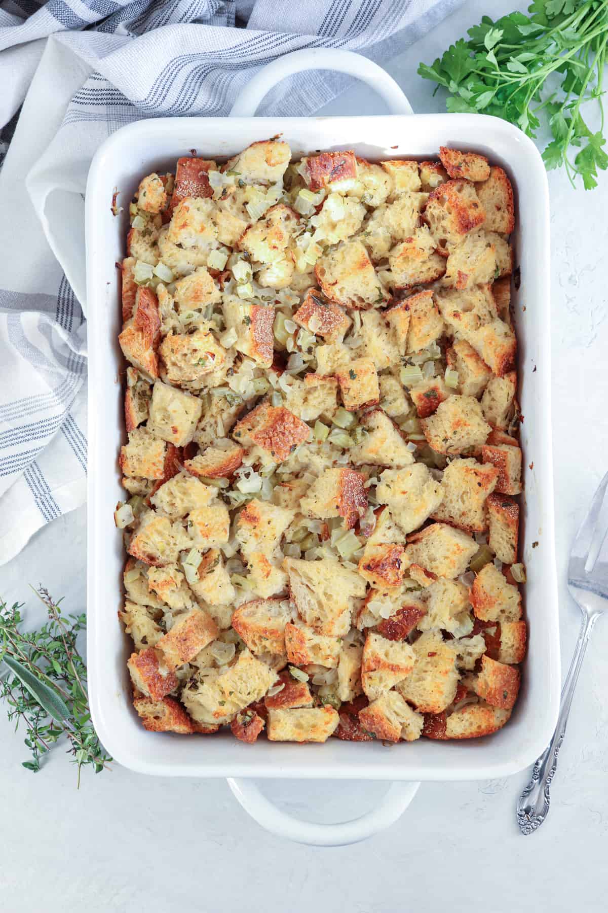 sourdough bread stuffing baked in a white rectangular baking dish.
