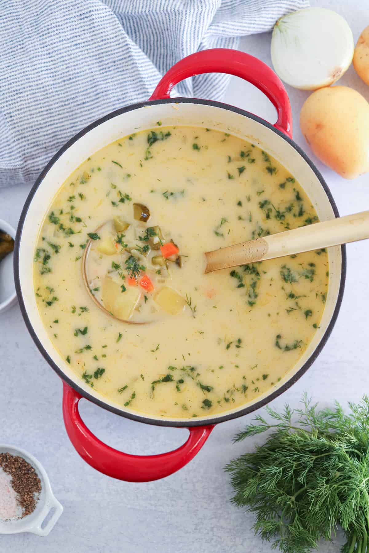 creamy dill pickle soup in a red dutch oven.