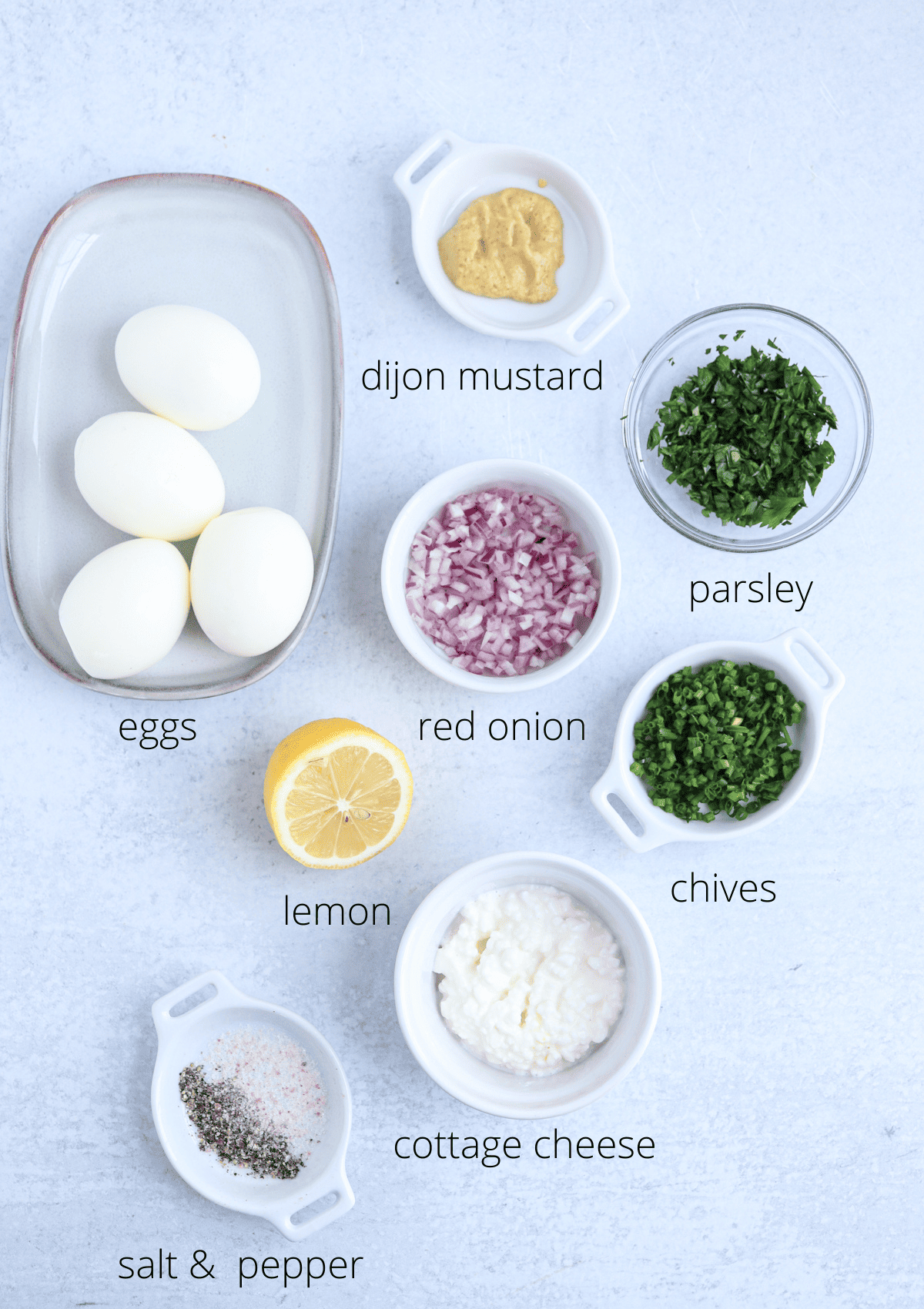 ingredients for making cottage cheese egg salad on gray background with captions.