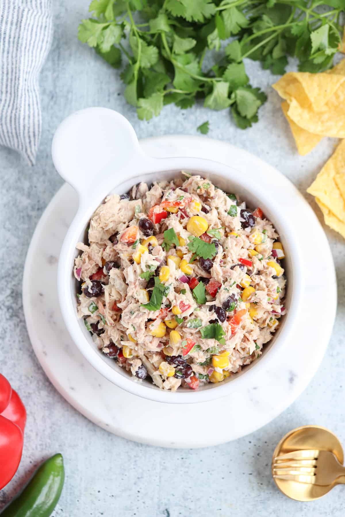 tuna salad with black beans, sweet corn, red peppers and fresh cilantro in a white bowl. 