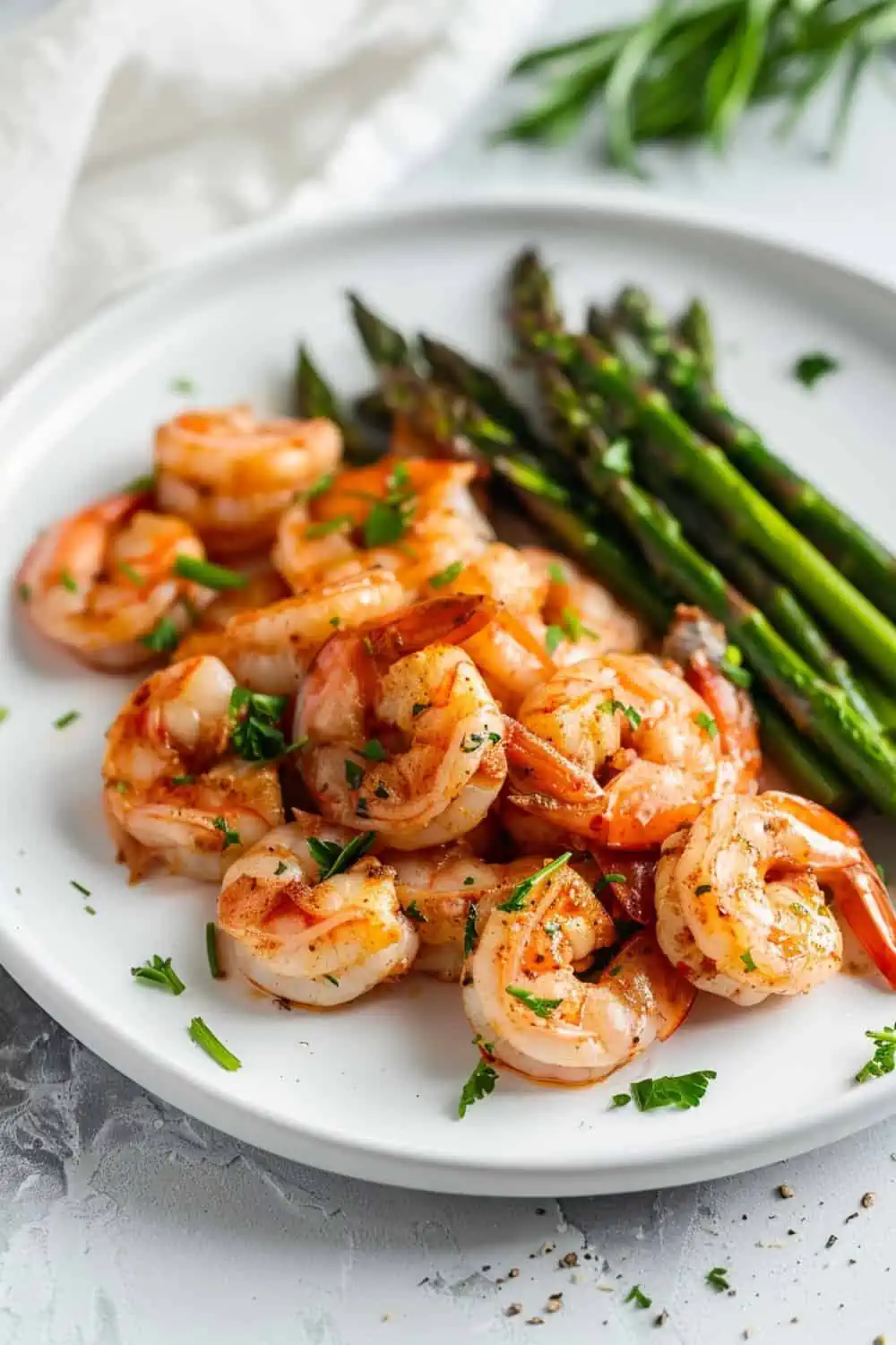 shtimp with asparagus on a white plate.