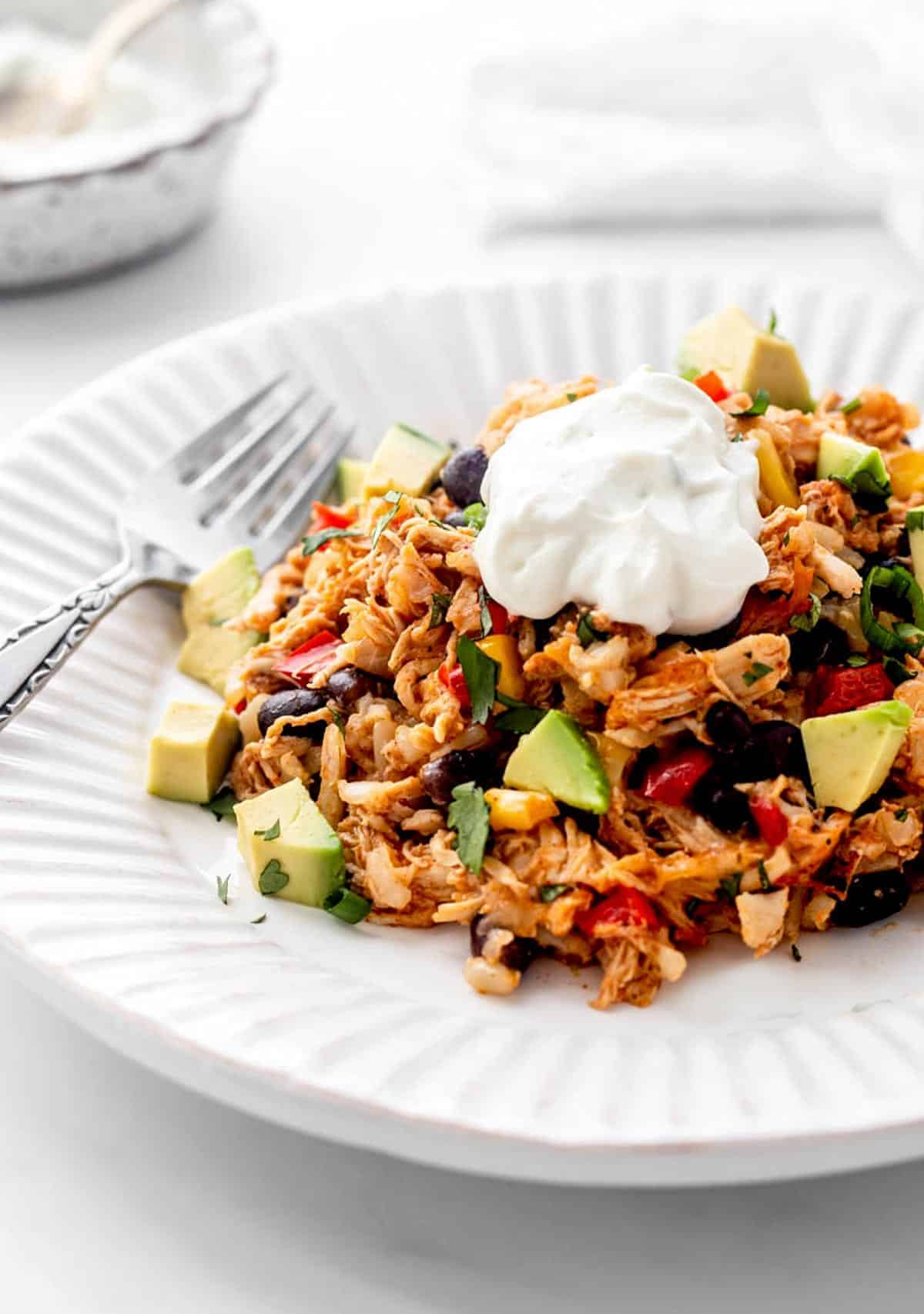 chicken burrito casseriole with avocado and sour cream.