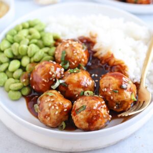 chicken meatballs in teriyaki sauce served with rice and edamame.