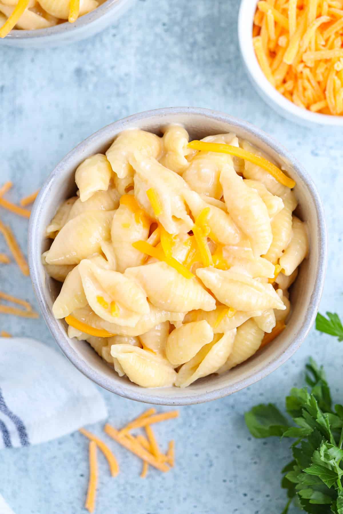creamy mac and cheese in a small greay bowl on gray background.