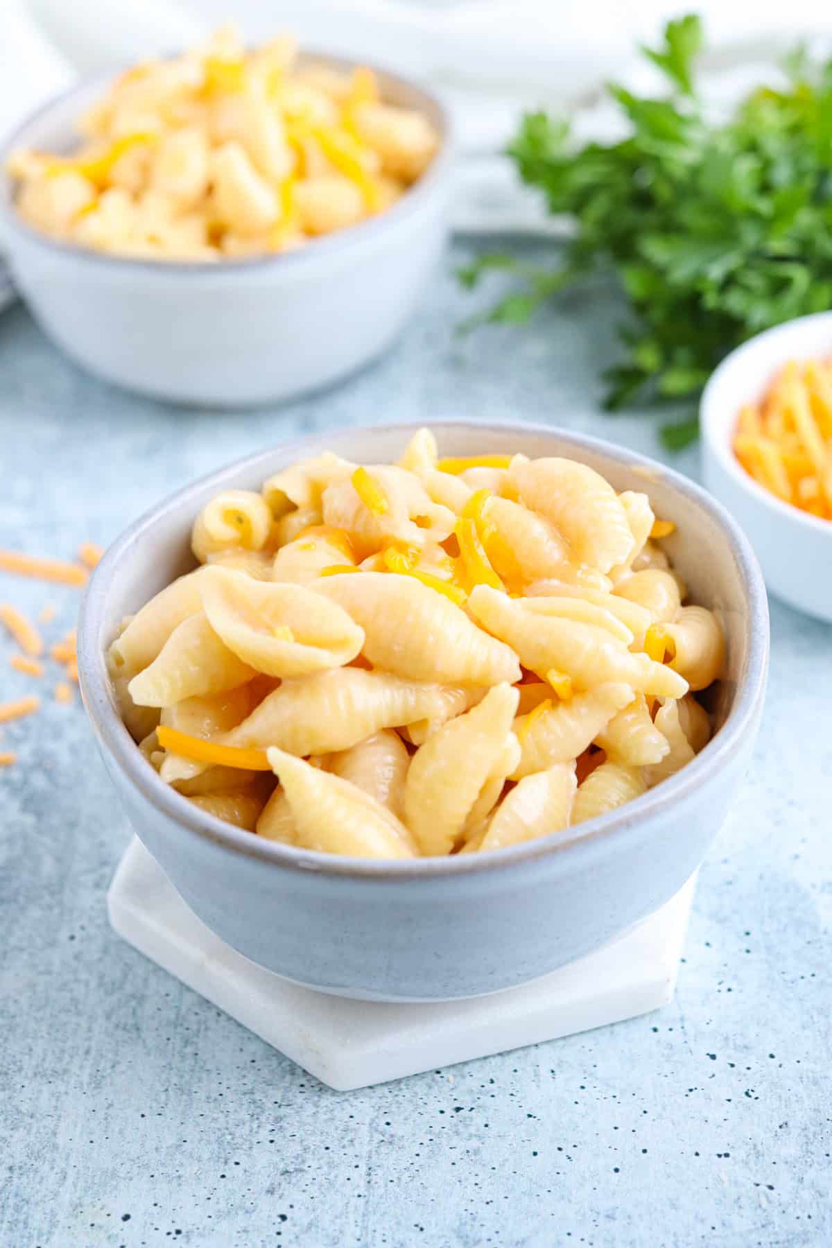 creamy mac and cheese in a small greay bowl on gray background.