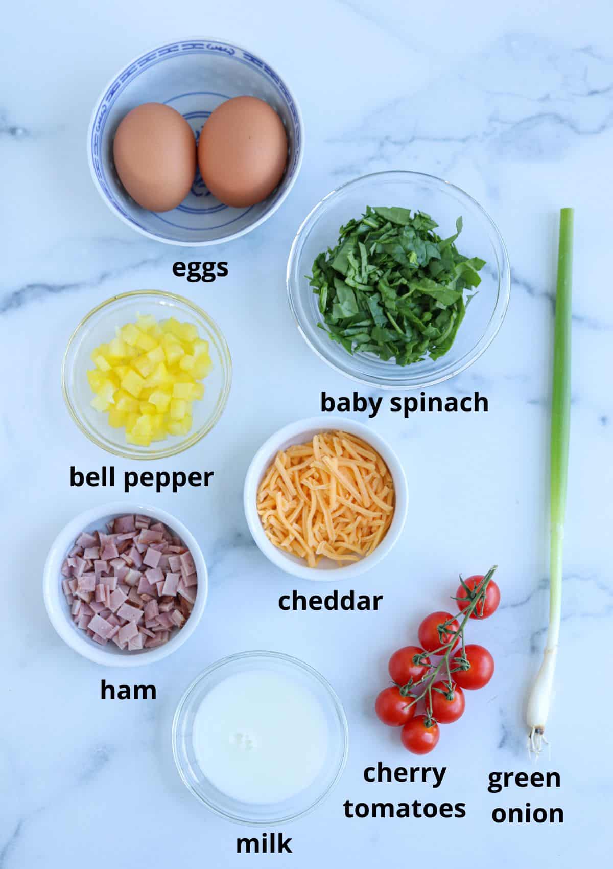 ingredients for making an air fryer omelette on marble surface with captions.