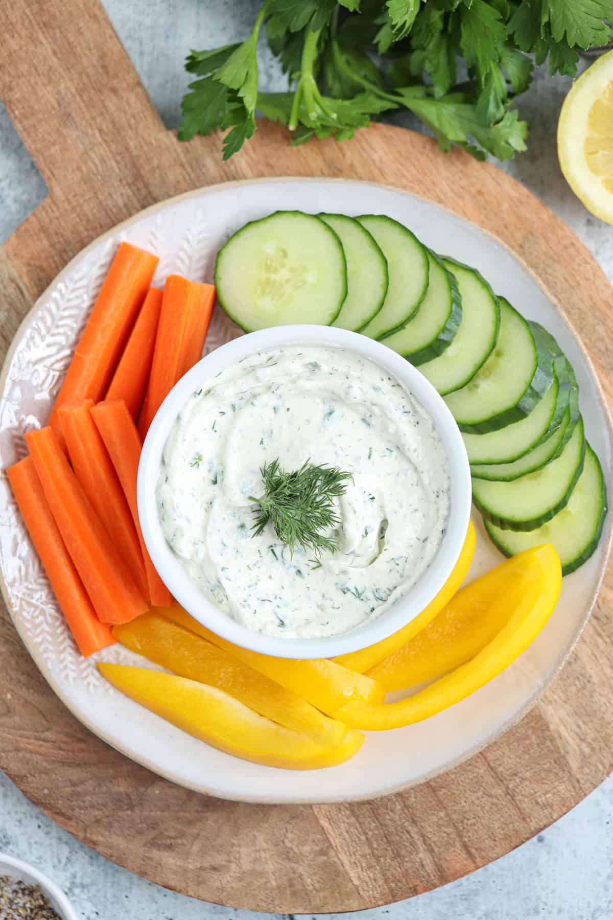 cottage cheese ranch dip in a small white dish on a plat surounded by fresh veggies.
