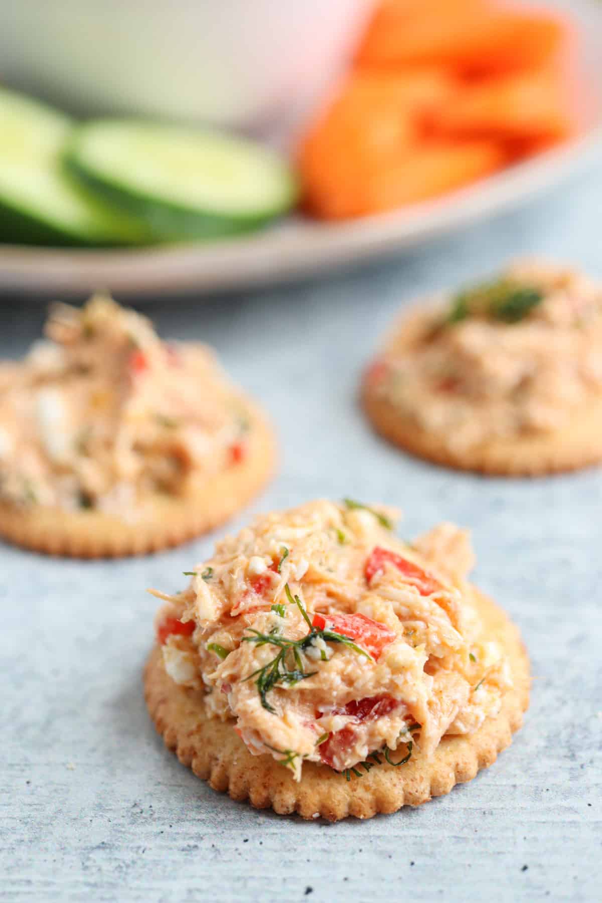 tuna spread on a cracker on gray surface. 