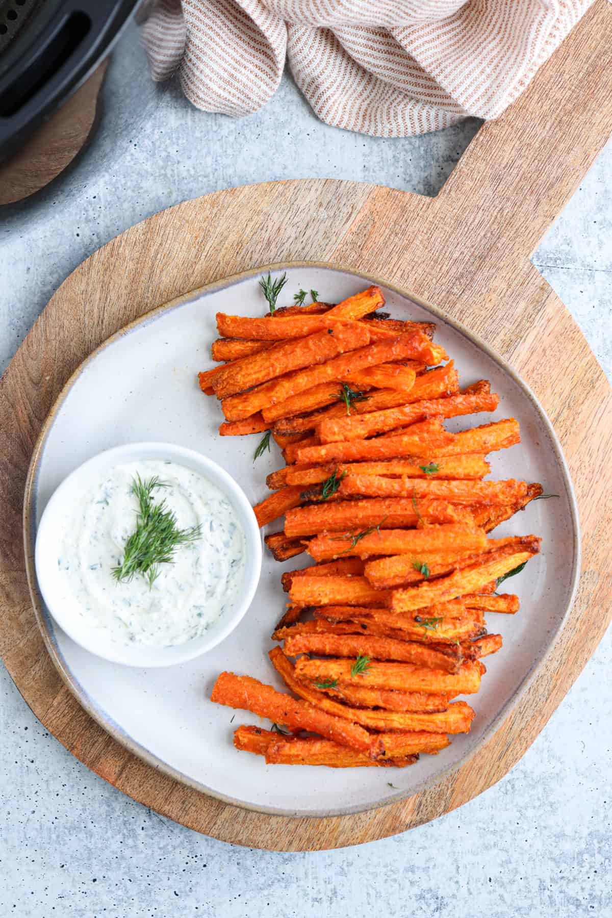 carrot fries on a gray plate with a side of ranch in a small bowl.