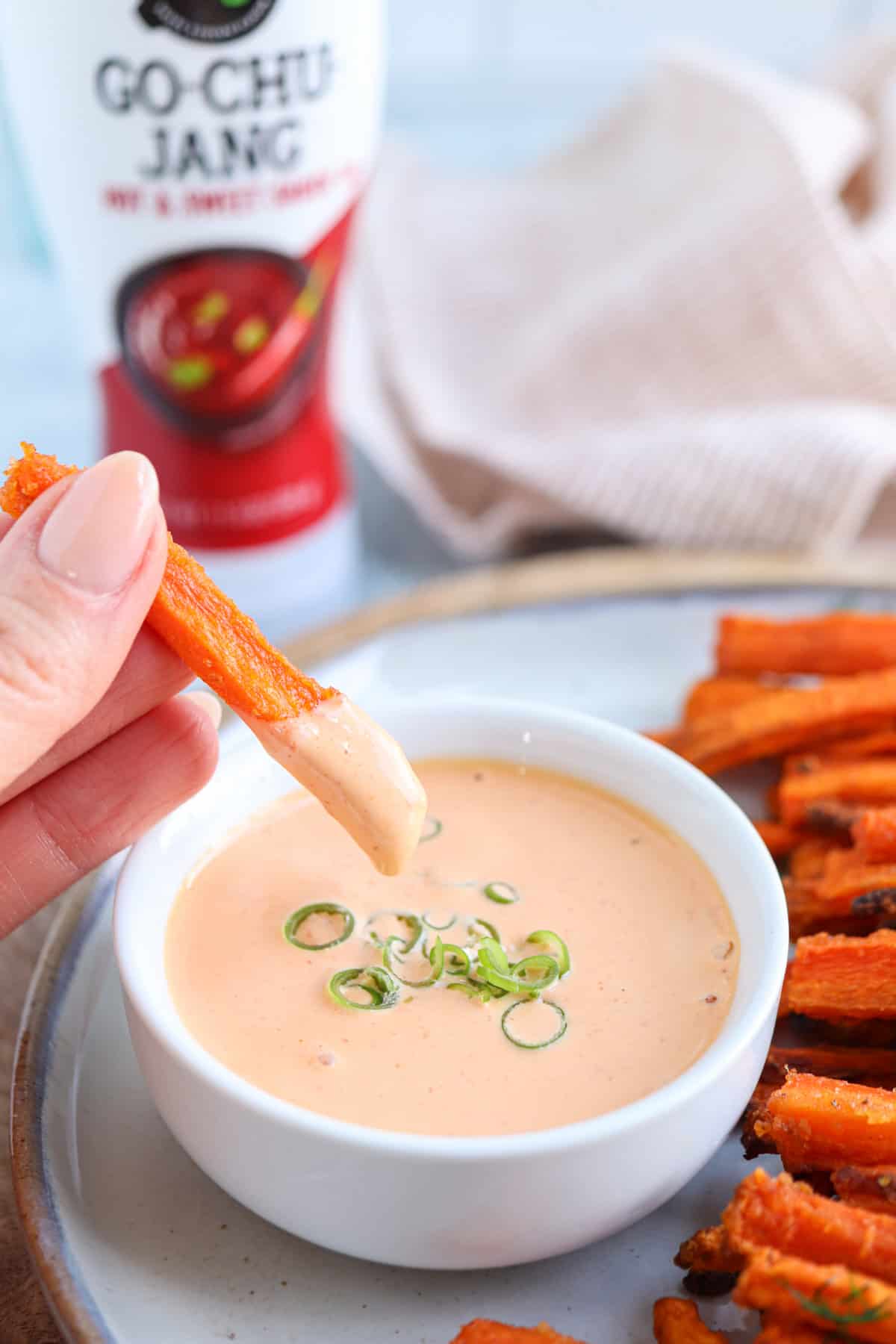 dipping a carrot fry in spicy mayo.