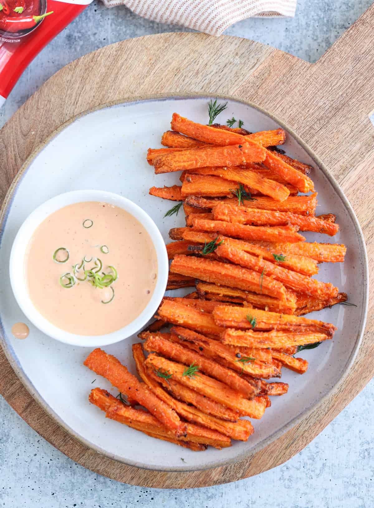 carrot fries on a gray plate with a side of spicy mayo in a small bowl.