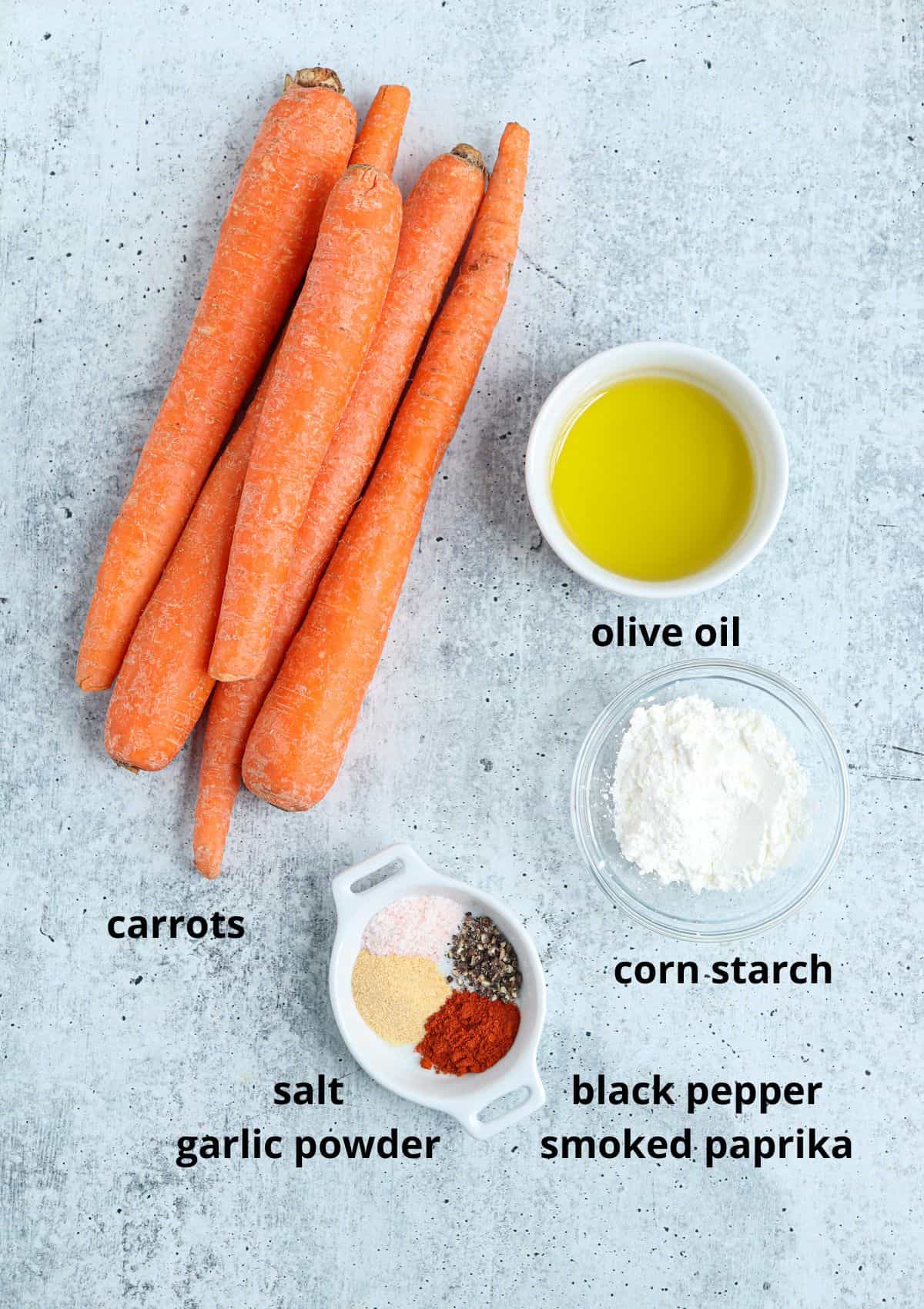 ingredients for making air fryer cxarrot fries on gray background with captions.
