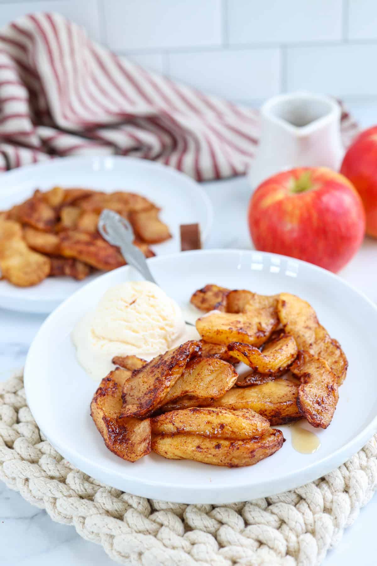 air fried apple slices on a white plate with vanilla ice-cream.