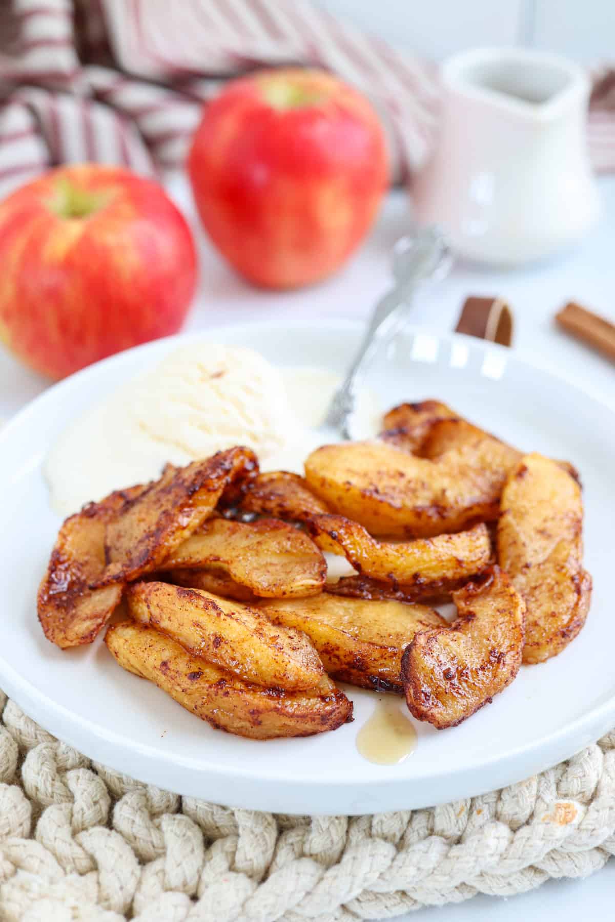 air fried apple slices on a white plate with vanilla ice-cream.