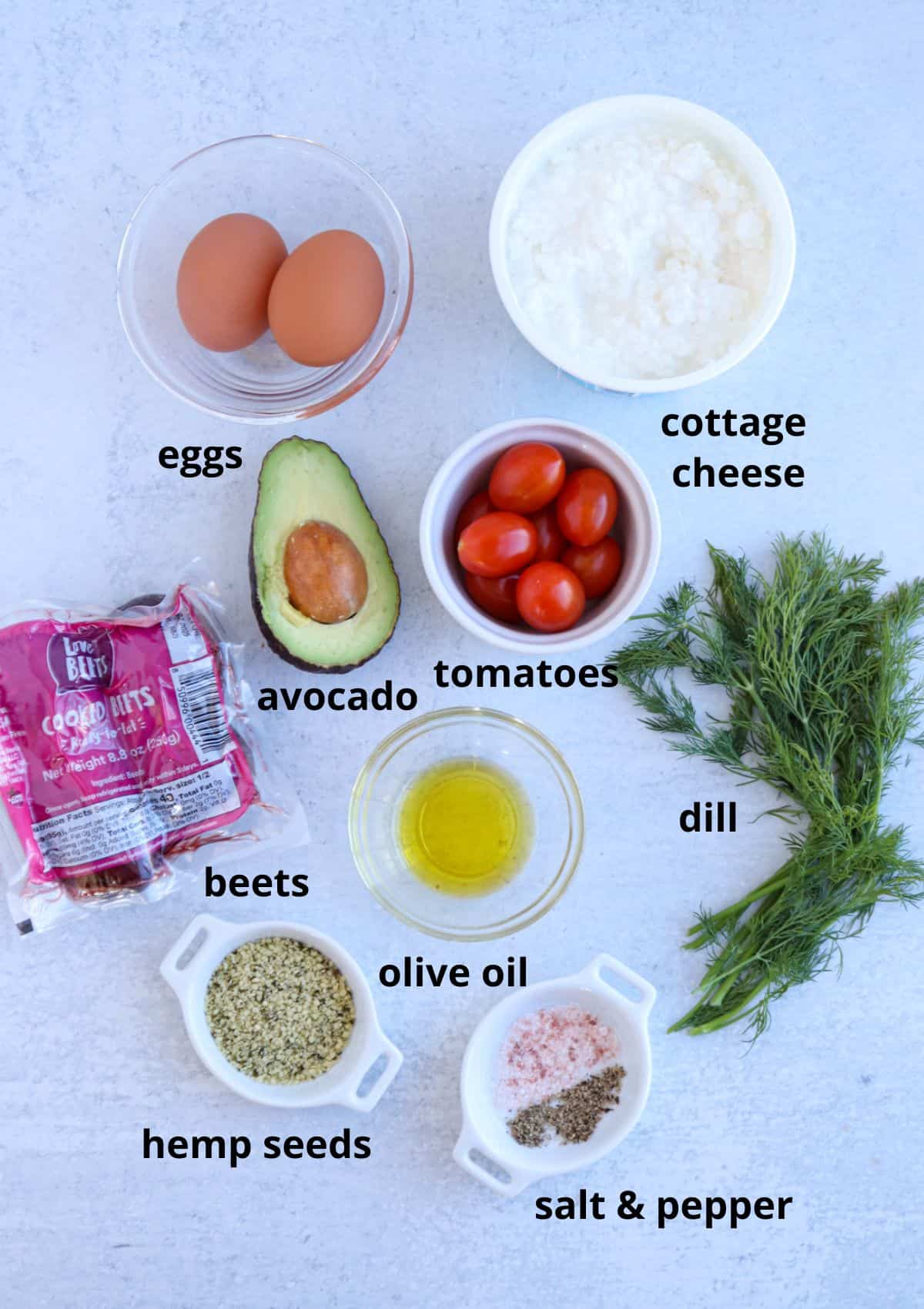 A delightful cottage cheese breakfast bowl awaits: eggs, creamy cottage cheese, ripe avocado, juicy tomatoes, fresh dill, packaged beets, olive oil drizzle, crunchy hemp seeds, and a sprinkle of salt & pepper—each ingredient labeled with care on a light surface.