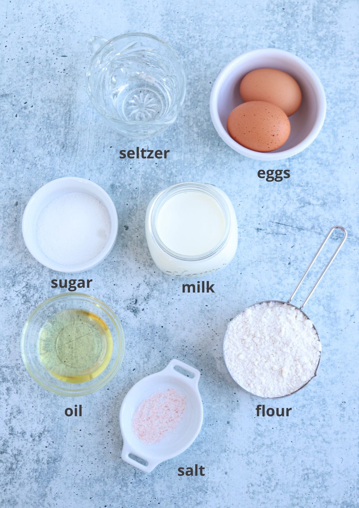 ingredients for making Polish crepes in small dishes with capions.